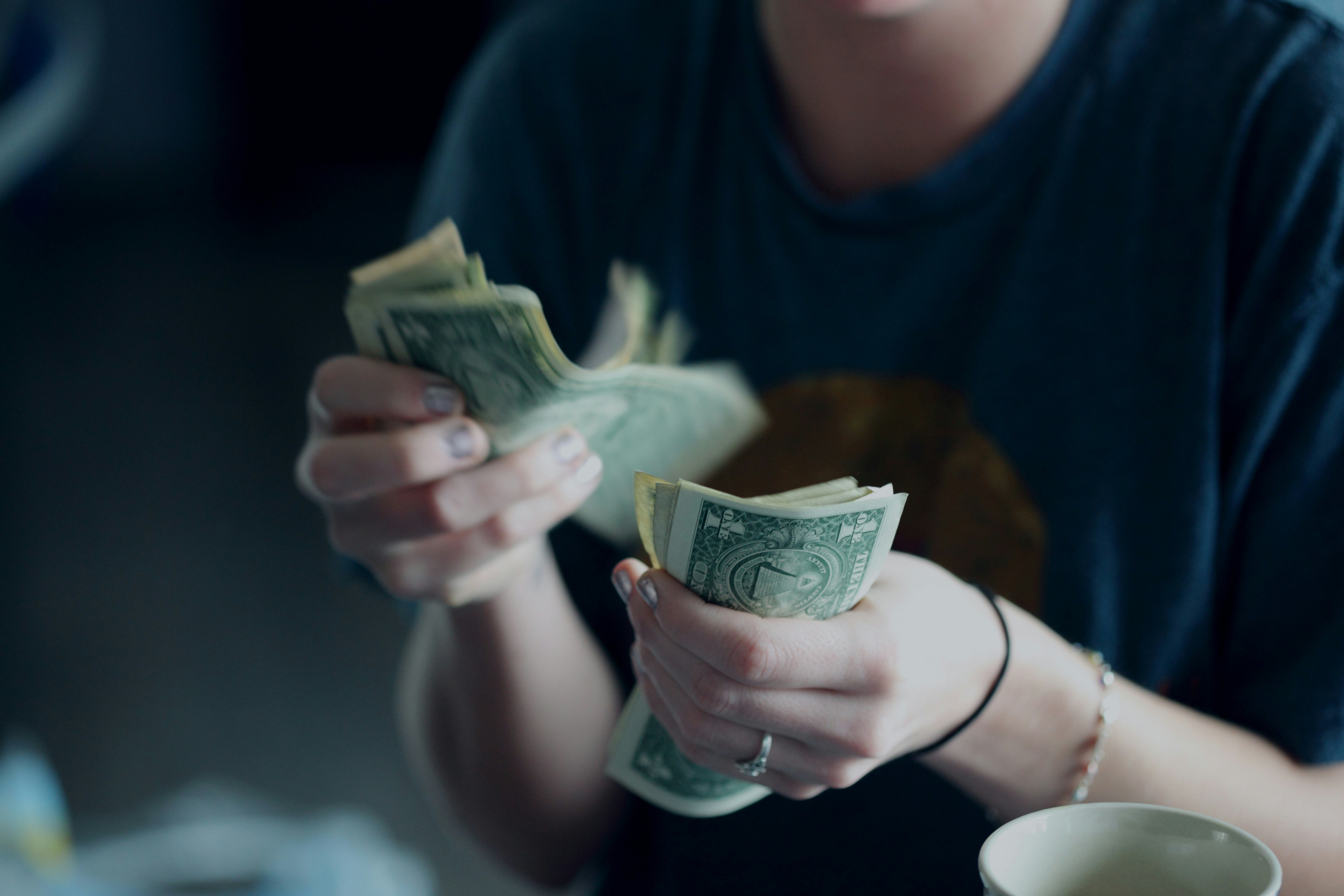 person counting money - Invested Capital